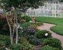 Photo of landscape designed by Adams Nursery with annual and perennial flowers and blooming and evergreen shrubs.